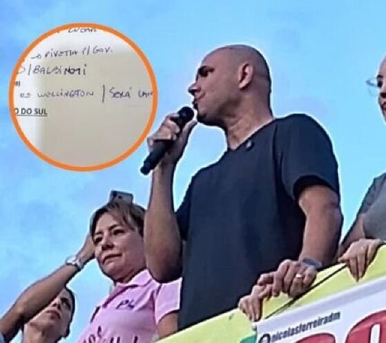 O prefeito de Cuiabá, Abilio Brunini (PL), em discurso na manifestação 'Acorda, Brasil!' na Praça do Choppão, em Cuiabá, e em destaque trecho de anotação do senador Flávio Bolsonaro (PL-RJ).